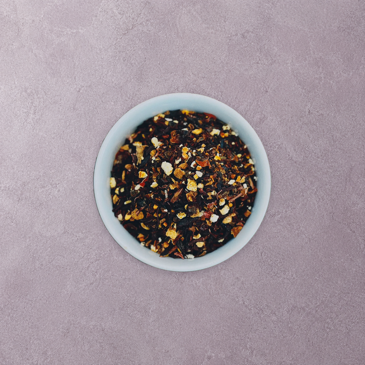 Wolf Ember Coffee Hibiscus Berry caffeine-free loose-leaf herbal tea in an artisan stoneware bowl